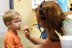 Two year-old Landon Zoss, son of Ensign Brandon Zoss stationed at the Nuclear Power Training Unit, has his face painted by volunteer Brandi Horne during the WaterPark Wonderland  hosted by Balfour Beatty Communities at Joint Base Charleston-Weapons Station, July 22. (U.S. Navy photo/ Mass Communication Specialist 3rd Class Brannon Deugan) 
