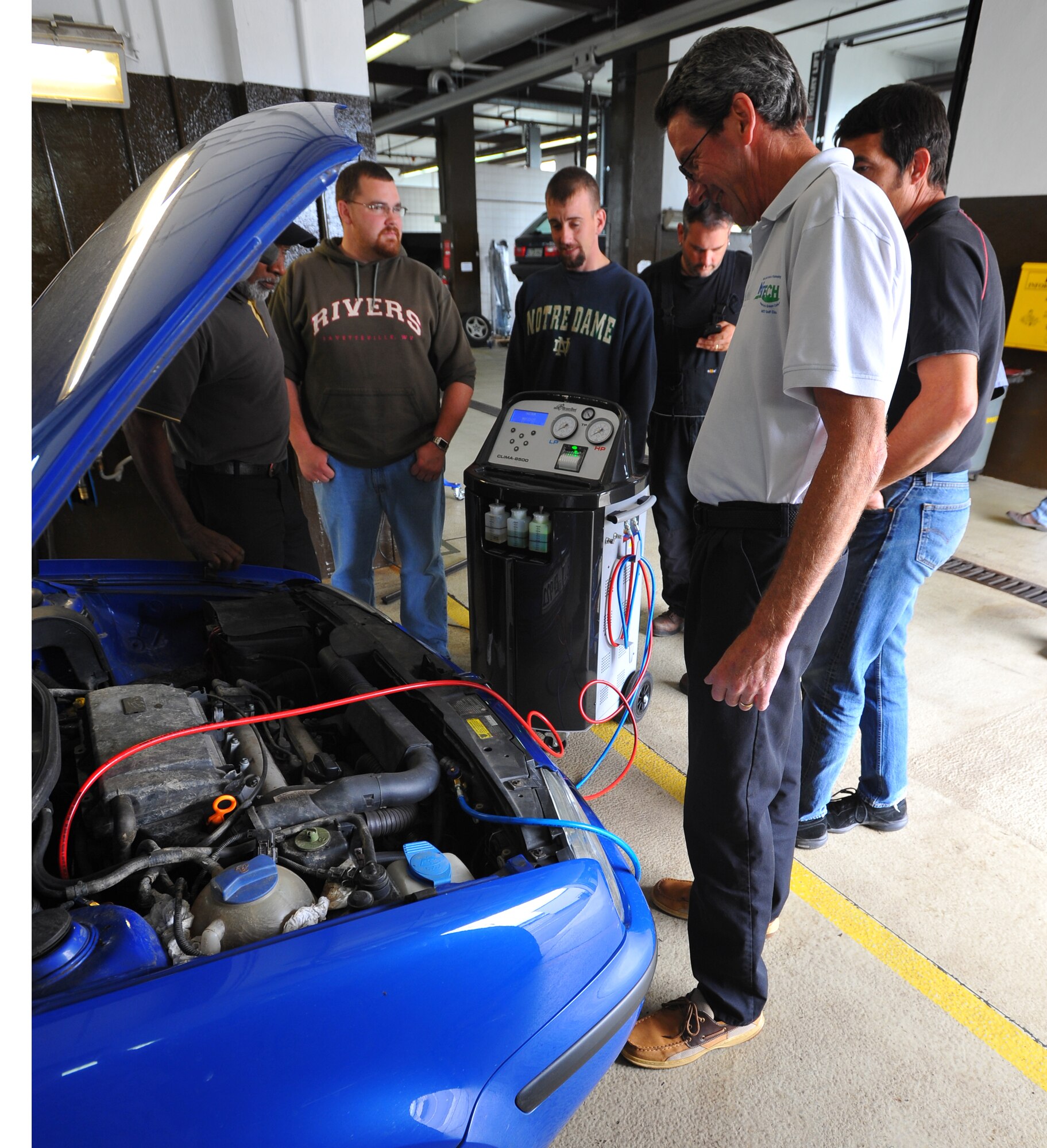 SPANGDAHLEM AIR BASE, Germany – Robert Kennedy, front, New England Institute of Technology instructor, explains to a class how to test and charge the air conditioning system on a vehicle during an automotive class here July 22. New England Tech sent an instructor here to teach a five-day advanced automotive class for Spangdahlem and Ramstein Air Base Force Support Squadron automotive mechanics. (U.S Air Force photo/Airman 1st Class Dillon Davis)