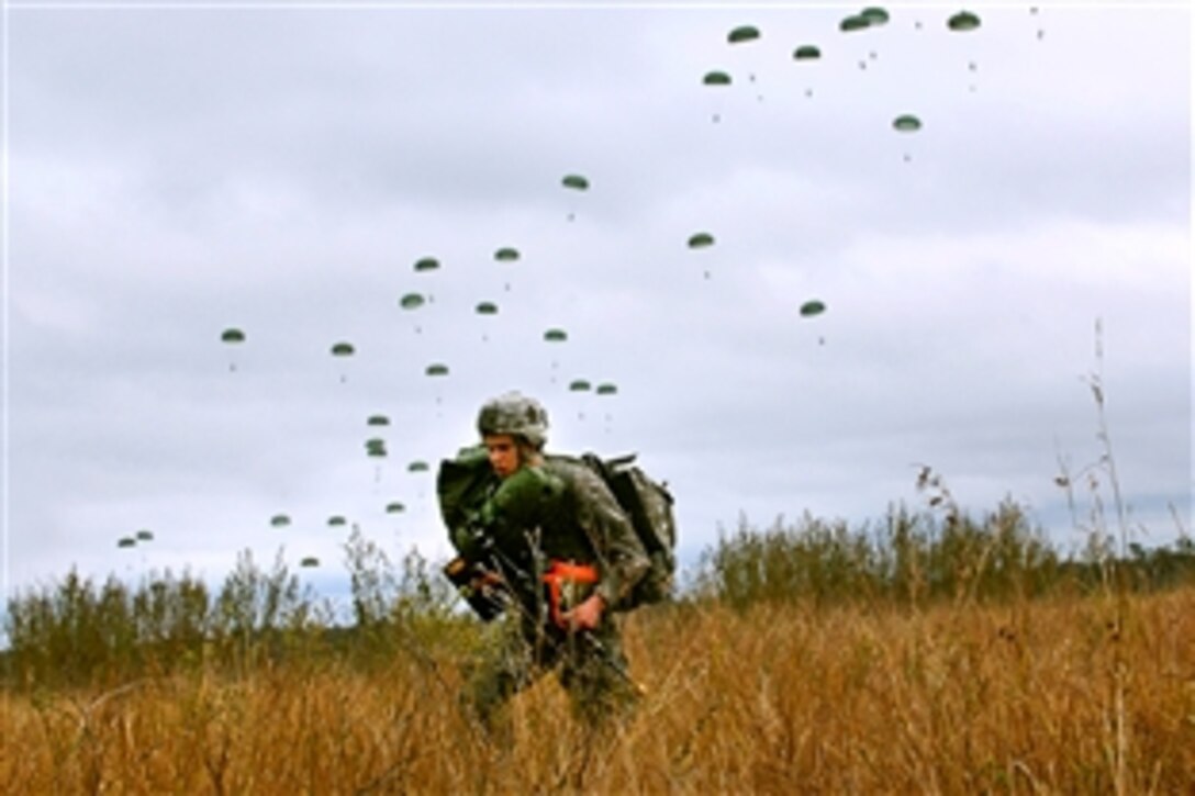 U.S. Army Spc. Derek Brown moves out of the drop zone as others parachute out of an Air Force C-17 Globemaster III aircraft and into the Shoalwater Bay training area during Talisman Saber 2011 in Queensland, Australia, July 17, 2011. The exercise trains U.S. and Australian forces to plan and conduct combined operations to improve combat readiness and interoperability. Brown is assigned to the 1st Battalion, 501st Parachute Infantry Regiment, Fort Richardson, Alaska. 