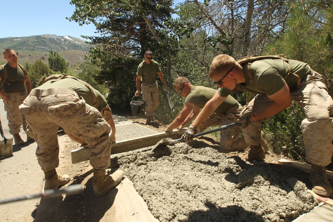 Combat Engineer’s with Company C., 3rd Engineer Support Battalion, pour concrete for a 500 foot sidewalk in support of the Marine Corps Mountain Warfare Training Center, July 26.