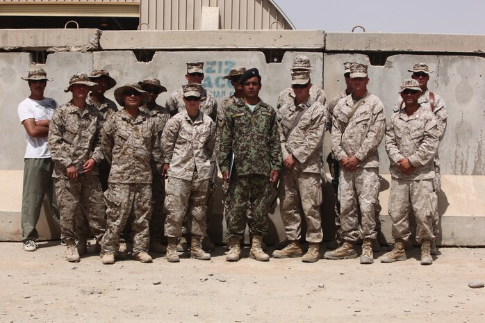 Marines from the 2nd Marine Logistics Group (Forward) Embedded Partnering Team pose for a picture with Sgt. Azim Sultanzi after a graduation ceremony at Camp Shorabak, Afghanistan, July 28, 2011.  Sultanzi, a soldier from the 215th Corps Logistics Brigade, Afghan National Army, graduated from the Joint Administration Course, which will allow him to efficiently complete administrative work like pay issues and monthly inspections.