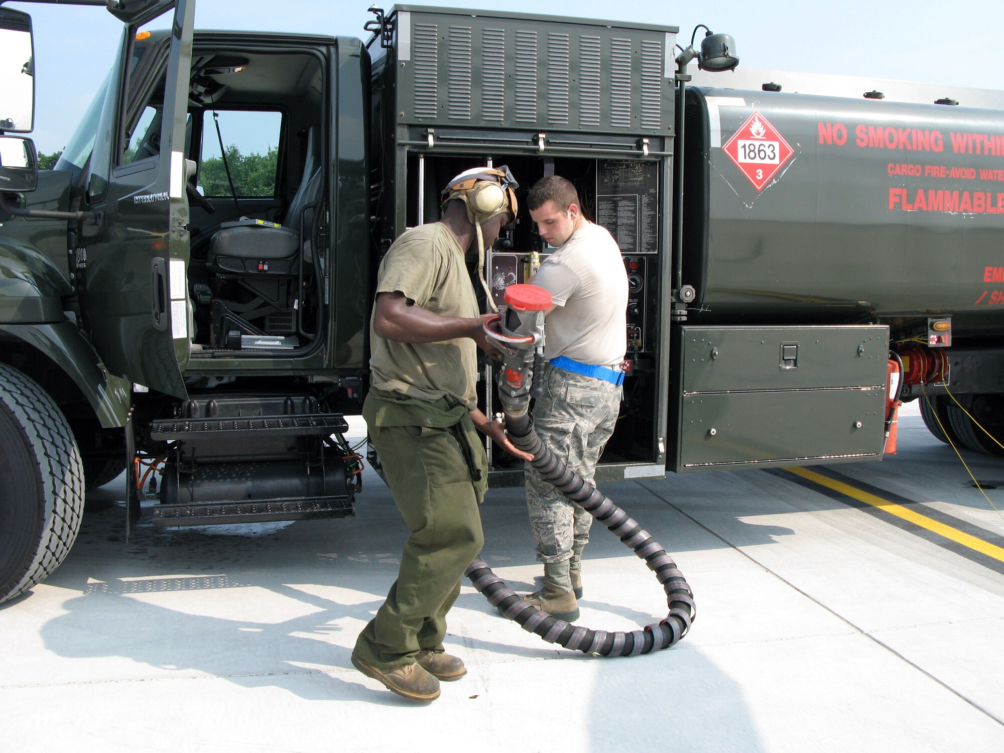 Air Force Airman Kyle Schoenfelt, right, a member of the 87th Logistics Readiness Squadron at Joint Base McGuire-Dix-Lakehurst, N.J., and Marine Corps Staff Sgt. F.O. Johnson from Heavy Marine Helicopter 772 “Hustlers” prepare to refuel Marine CH-53 Super Stallion helicopters, July 8, 2011. (Department of Defense photo by Donna Miles/Released)
