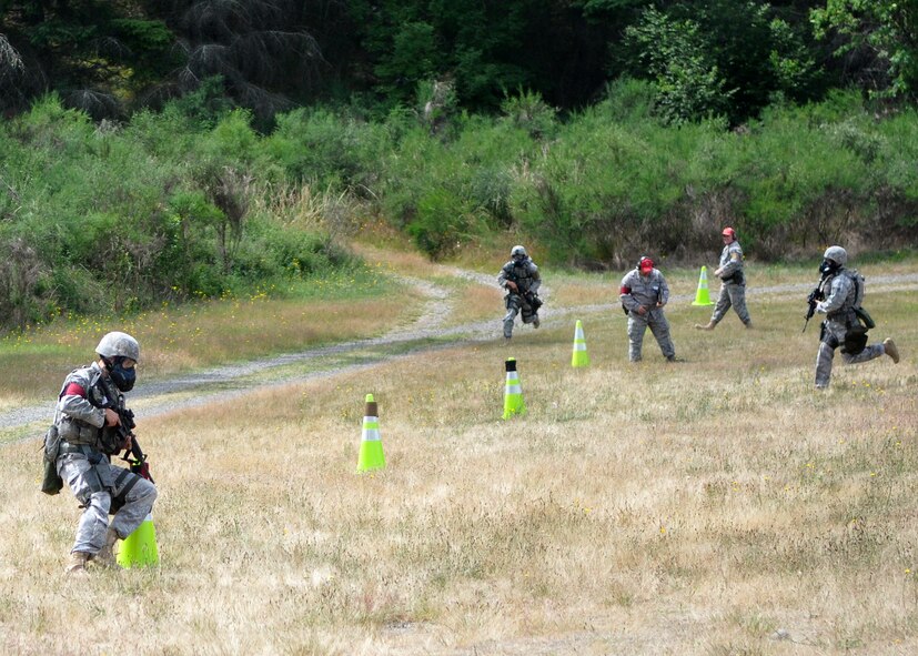 The four-person 627th Security Forces Squadron Rodeo team sprints to marked cones during a combat weapons course as part of Air Mobility Rodeo July 26, 2011, at Joint Base Lewis-McChord, Wash. The course required the team to fire an M-16 and a pistol. Rodeo is a bi-annual competition that encompasses all aspects of Air Mobility Command, including aerial port, aeromedical evacuation, maintenance, security forces, and financial management. (U.S. Air Force Photo/Airman 1st Class Leah Young)