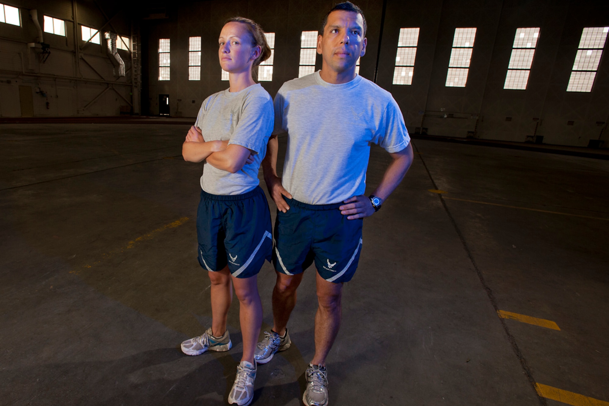 Air Force Staff Sgt. Marian McLaughlin, a pharmacy technician with 673d Medical Support Squadron, originally from Madison, Wisc., left, and Tech. Sgt. Jose Garza, a low-observable technician with the 477th Fighter Group, from Anchorage, pose for a photograph Tuesday, in Hangar 5, the former aircraft hangar-turned-fitness center on Joint Base Elmendorf-Richardson. McLaughlin and Garza were recently chosen to be the representatives from JBER at the 15th annual Air Force Marathon at Wright Patterson Air Force Base, Ohio, Sept. 17. (U.S. Air Force photo/Justin Connaher)