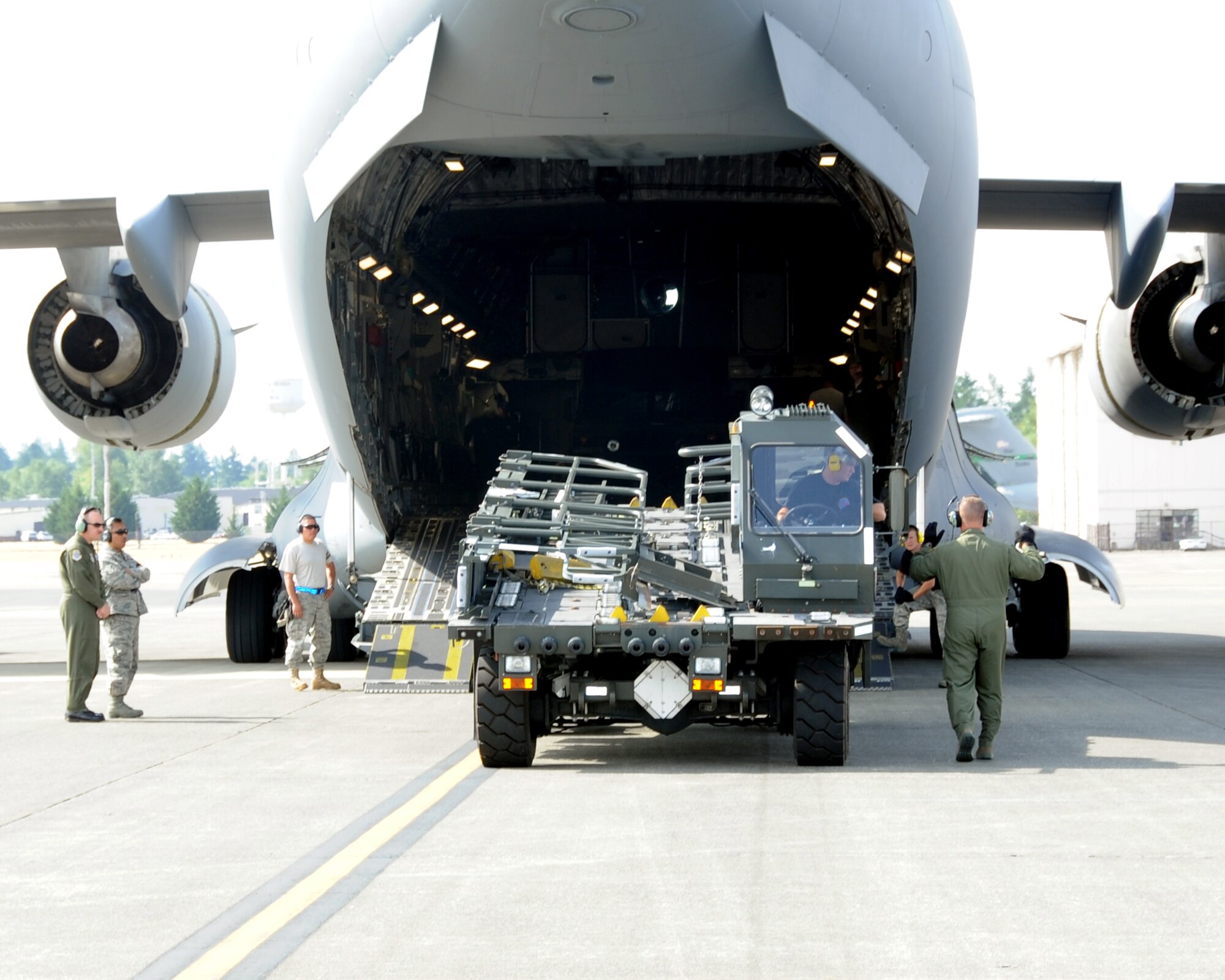 JOINT BASE LEWIS-MCCHORD, Wash. – 2011 Air Mobility Command Rodeo umpires watch as Staff Sgt. Eric Sims, 97th Logistics Readiness Squadron Rodeo Team member from Altus Air Force Base, Okla., backs a 25k Halvorson into a C-17 Globemaster III during the engine running on-load and off-load event July 27. This timed event simulates expedient on-load and off-load of cargo in a wartime environment using a five member team. (U.S. Air Force photo by Airman 1st Class Kenneth W. Norman / Released / 97th Air Mobility Wing Rodeo Public Affairs)