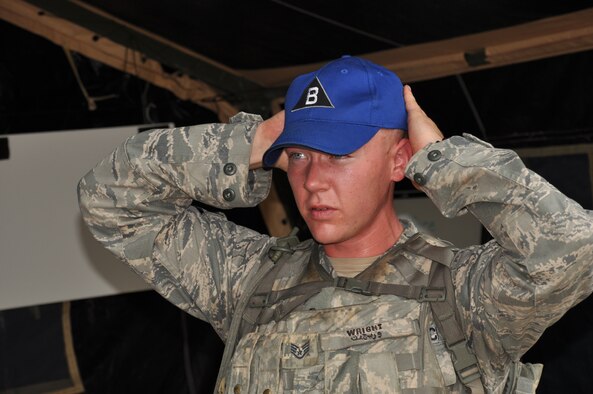 Senior Airman Luke Wright, 92nd Security Forces Squadron, trades his kevlar helmet for his Fairchild Rodeo team ball cap following the security forces tactics exercise July 25 as part of the Air Mobility Rodeo at Joint Base Lewis-McChord. He was the team leader for an exercise involving delivery of humanitarian aid to a village. (U.S. Air Force Photo/Tech. Sgt. Jennifer Buzanowski)