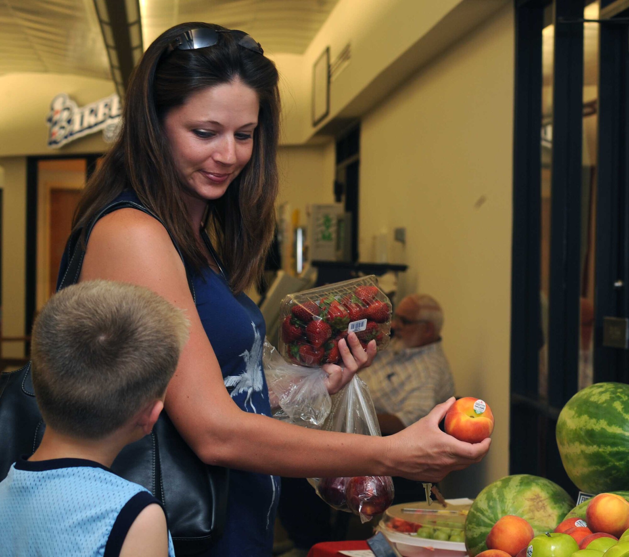 Randi Fraser and her son, Steven, shop for fruits and vegetables at a farmer’s booth July 26 on Grand Forks Air Force Base, N.D.  The bases Army and Air Force Exchange Service provided multiple display booths to recognize 116 years of service and support to America's military. (U.S. Air Force photo by Senior Airman Amber Bennett)