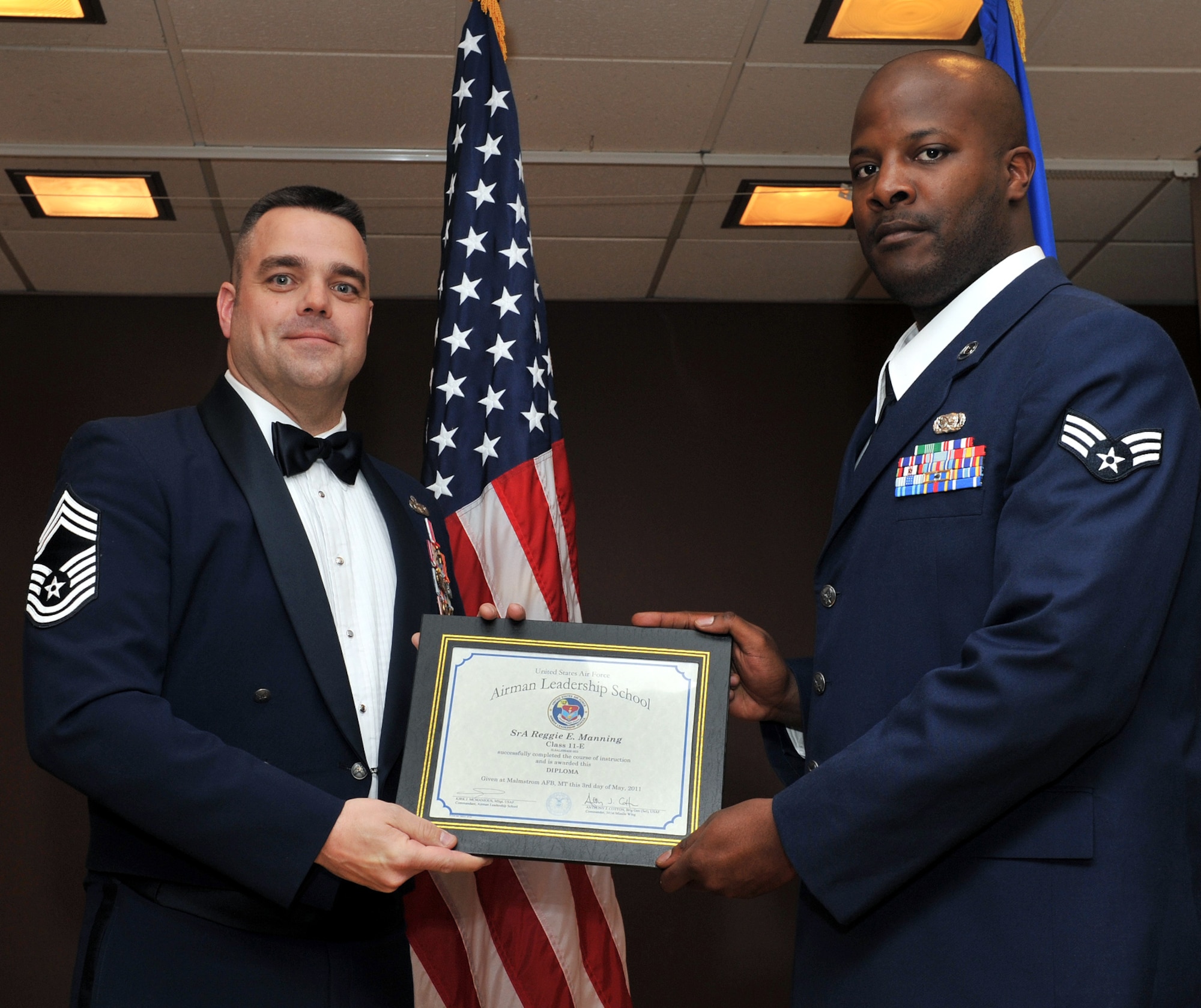 Chief Master Sgt. Paul Tranetzke poses with Senior Airman Reggie Manning after presenting him with his ALS graduation certificat May 3. Tranetzke was acting command chief at the time. Manning is a member of the 341st Logistic Readiness Squadron (U.S. Air Force photo/John Turner)