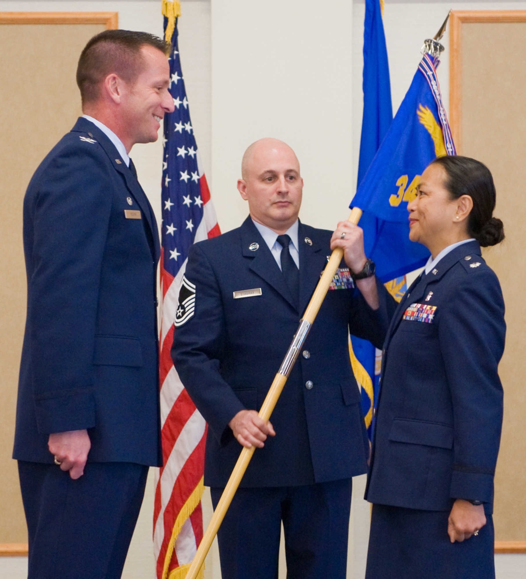 Lt. Col. Editha Heberlein accepts command of the 341st Medical Support Squadron from Col. Bruce Roehm, 341st Medical Group commander, July 15 at the Grizzly Bend.  Senior Master Sgt. Mark Stagray, NCO in charge of medical equipment repair, looks on.  (U.S. Air Force photo/Beau Wade)