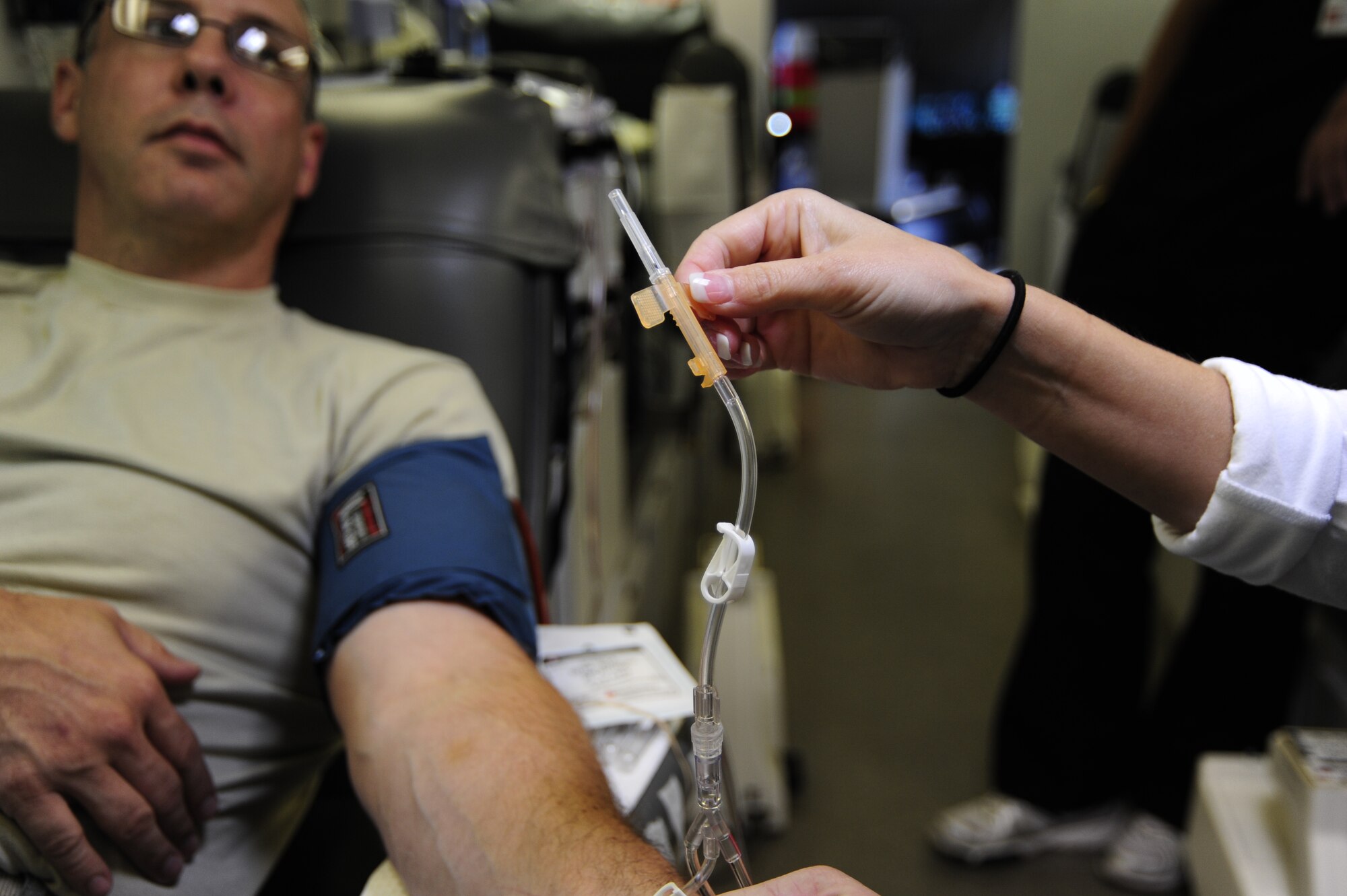 Senior Master Sgt. Adam Wooley, 1st Special Operations Equipment Maintenance Squadron, waits to be inserted with a needle by a Northwest Florida Blood Services technician during a blood drive held at Hurlburt Field, Fla., July 20, 2011.  The 1st Special Operations Medical Group coordinates blood drives with the NFBS every two months.  (U.S. Air Force Photo by Airman Naomi Griego)