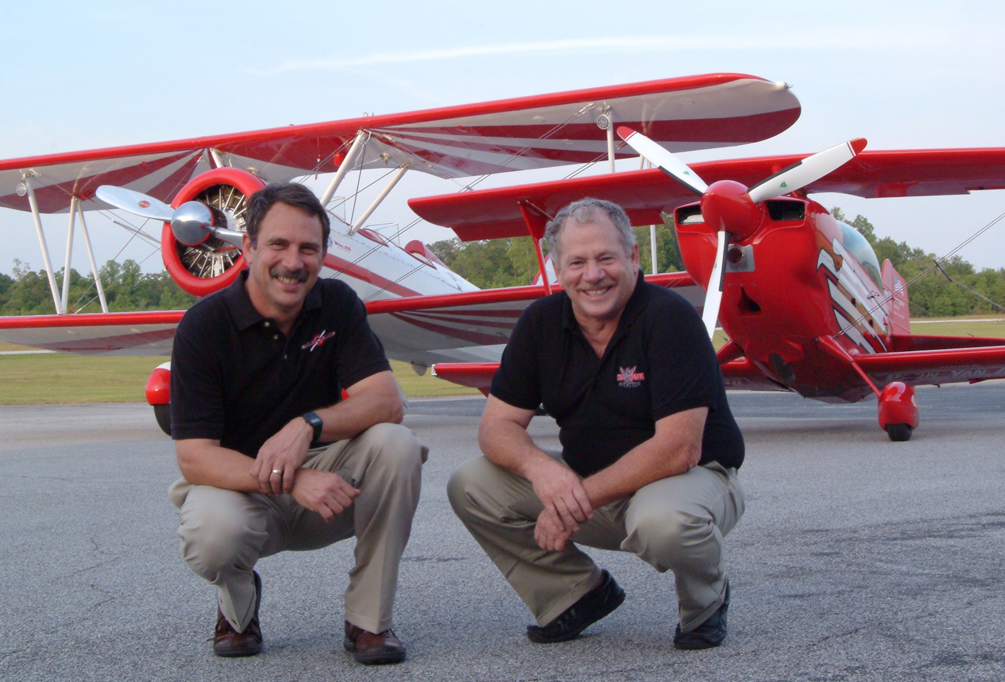 Pilots Gary Rower, left, and Buck Roetman pose in front of their aircraft. The two are slated to perform during the "Flight Over the Falls" Open House July 30-31. (Courtesy photo)