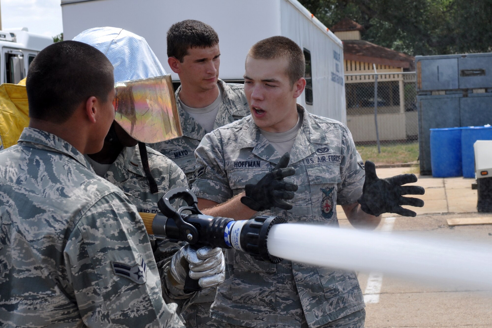 Airman 1st Class Logan Hoffman, a firefighter with the 2nd Bomb Wing, gives guidance to a member of the Chaplain Candidate Intensive Internship Program operating a water hose at Barksdale Air Force Base, La. July 20, 2011.  Members of the program visit various Air Force bases to learn the jobs and better understand the ministerial needs of Airmen. (U.S. Air Force photo/Staff Sgt. Ted Daigle)