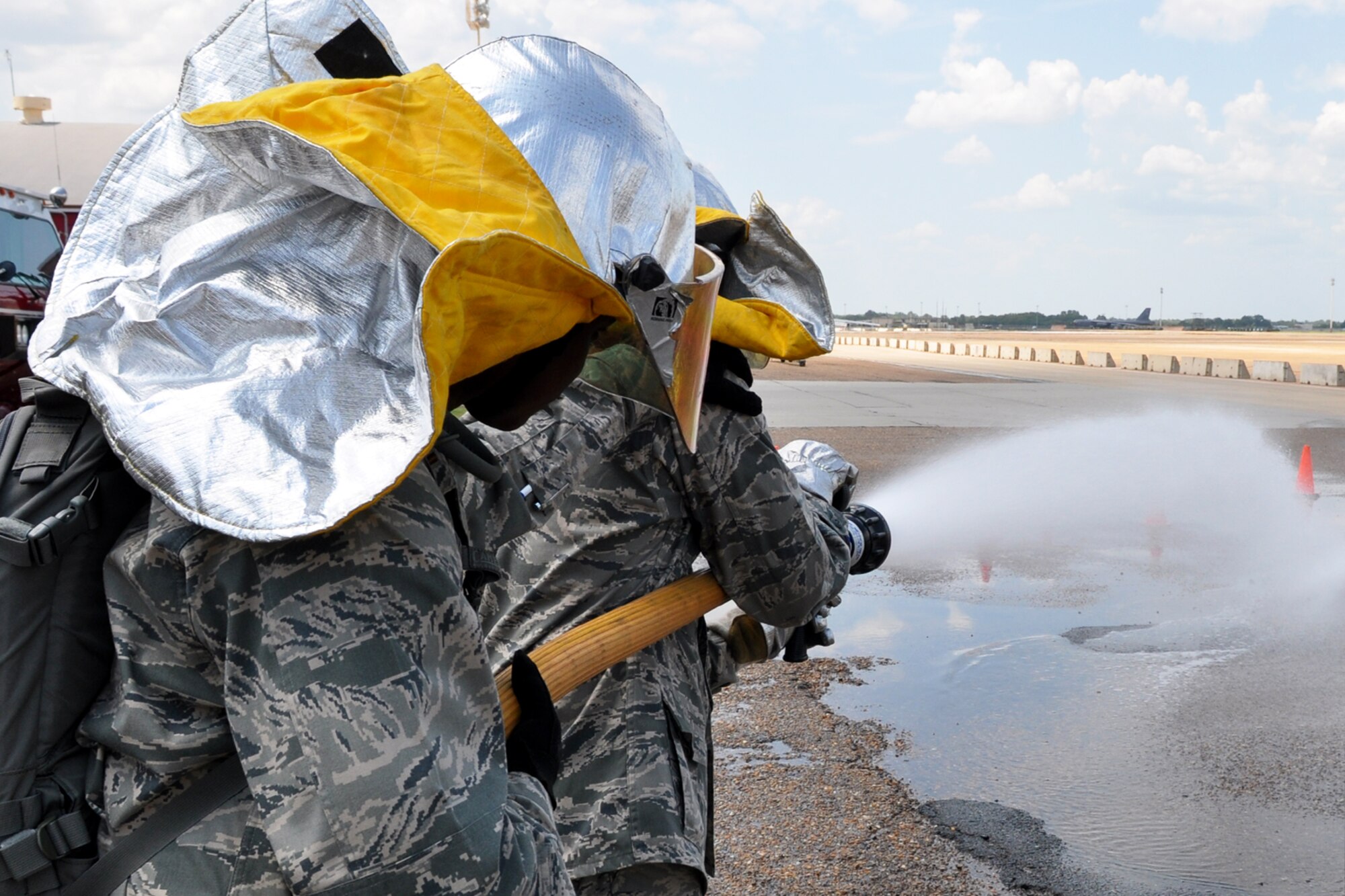 Two members of the Chaplain Candidate Intensive Internship Program try their hand at using a fire hose at Barksdale Air Force Base, La. July 20.  The program is designed for incoming U.S. Air Force Reserve chaplains to get an overview of the different ministries that exist in the military.  The candidates visited the 2nd Bomb Wing Fire Station to learn more about the work of Air Force firefighters and their specific ministerial needs. (U.S. Air Force photo/Staff Sgt. Ted Daigle)
