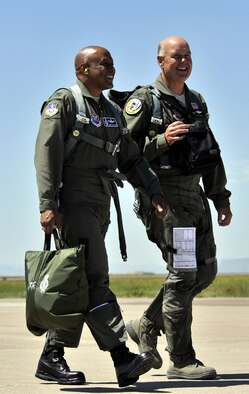 Col. Anthony Cotton (left) and Col. Pete Hronek stroll across the flightline to the aircraft hangar July 7. The two commanders from the east and west ends of Great Falls are good friends both on and off duty. (U.S. Air Force photo/John Turner)