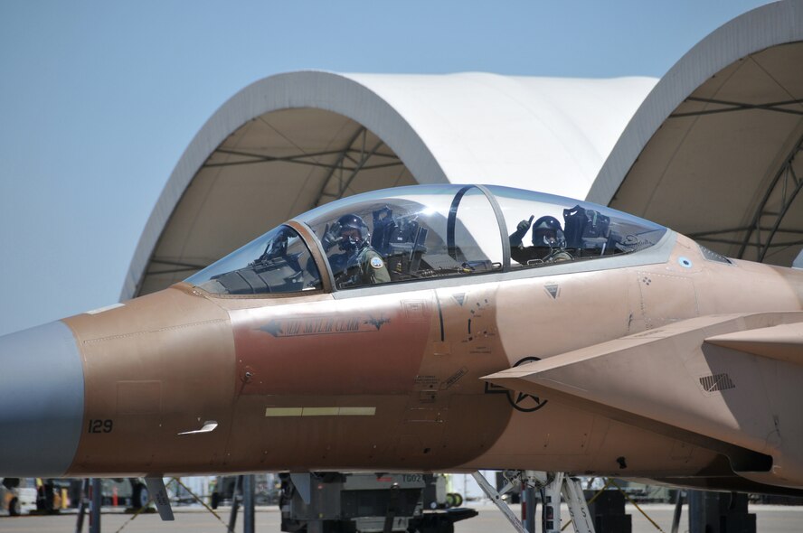 Col. Anthony Cotton, 341st Missile Wing comander, gives a thumbs up while Col. Pete Hronek, 120th Fighter Wing commander waves to the media, as they begin taxiing out of the hangar July 7.  Hronek gave Cotton a more than one-hour incentive ride in an F-15. (U.S. Air Force photo/ Senior Master Sgt. Eric Peterson)