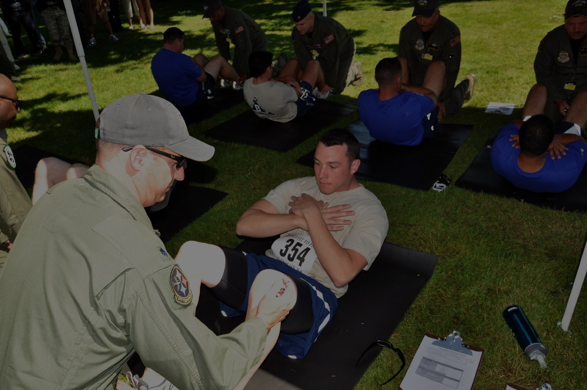 Staff Sgt. Michael Burton, 92nd Aircraft Maintenance Squadron, does one minute of sit-ups with his four teammates as part of the Air Mobility Rodeo's Air Force fitness test challenge July 24. A Fairchild KC-135 aircrew, and Airmen from security forces as well as the finance office are competing in events all week. (U.S. Air Force Photo/Tech. Sgt. Jennifer Buzanowski)