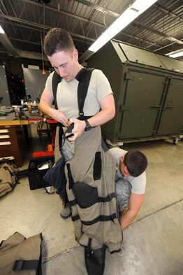 SEYMOUR JOHNSON AIR FORCE BASE, N.C. - Airman 1st Class Justin Beasley, 4th Civil Engineer Squadron explosive ordnance disposal apprentice, helps Staff Sgt. Justin Walter, 4th CES EOD craftsman, put on an EOD 9 Bomb Suit July 26, 2011. The suit is designed to protect the individual in case the device they are diffusing explodes. Beasley hails from Wilmington and Walters hails from Greenville, Tenn. (U.S. Air Force photo/Senior Airman Gino Reyes) (Released)