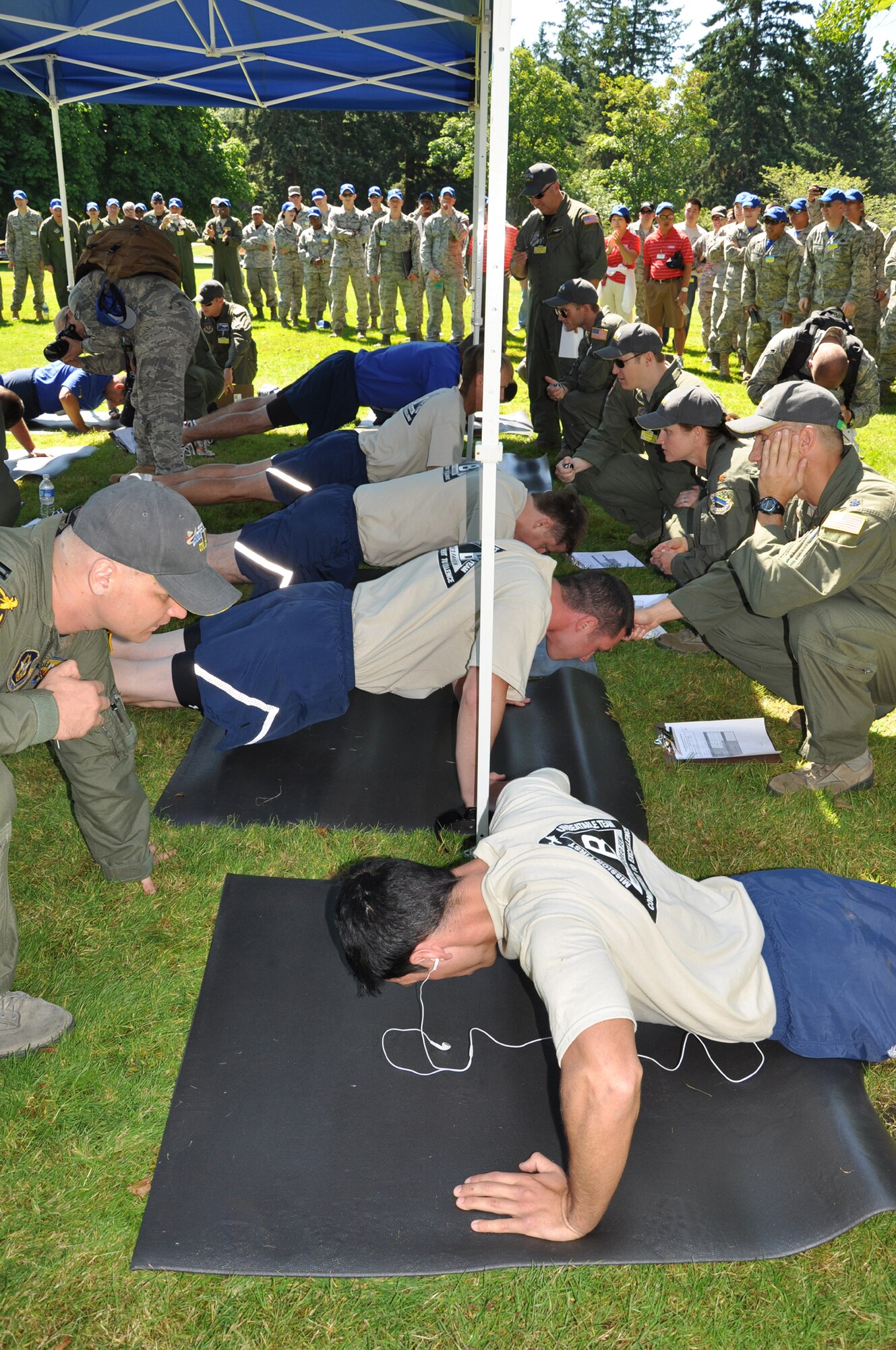 From front to back, after opening ceremonies for the Air Mobility Rodeo, Joint Base Lewis-McChord, Wash., July 24 participating units competed against each other in the Air Force fitness test. Five of Fairchild’s Airmen – four competitors and the team chief -do one minute of pushups. From front to back: Senior Airman Alexander Aun, 92nd Security Forces Squadron; Staff Sgt. Michael Burton, 92nd Aircraft Maintenance Squadron; Capt. Jim Blech, 92nd Operations Support Squadron, and Lt. Col. Brad Hamby, 92nd Air Refueling Squadron. Hidden on the other side of the opponent is Senior Airman Lyndell Bowie, 92nd Comptroller Squadron. (U.S. Air Force Photo/Tech. Sgt. Jennifer Buzanowski)