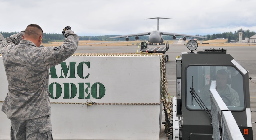 An Airman signals to the driver of a Halvorsen loader, July 26, 2011, at Joint Base Lewis-McChord, Wash., during a 25K loader driving course. The event was part of Air Mobility Rodeo 2011, a biennial international competition that focuses on mission readiness, featuring airdrops, aerial refueling and other events that showcase the skills of mobility crews from around the world. (U.S. Air Force photo/Airman 1st Class Jared Trimarchi) 
