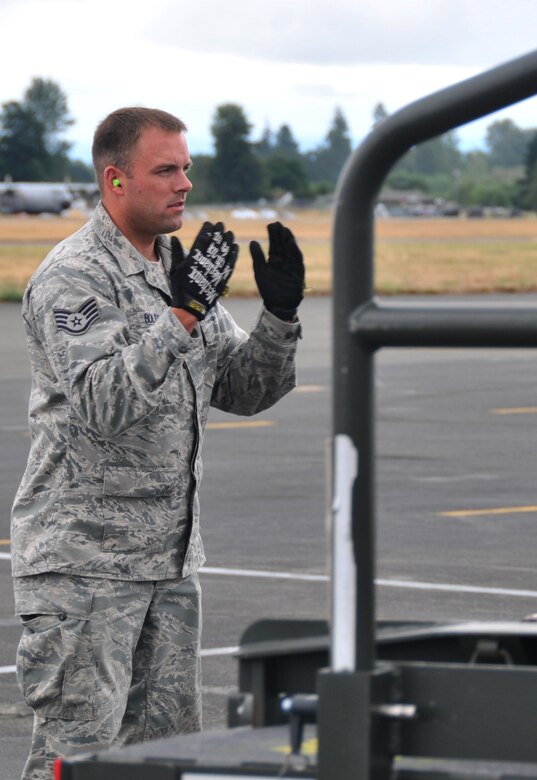 An airman directs the driver of a Halvorsen loader, July 26, 2011, at Joint Base Lewis-McChord, Wash., during a 25K loader driving course. The event was part of Air Mobility Rodeo 2011, a biennial international competition that focuses on mission readiness, featuring airdrops, aerial refueling and other events that showcase the skills of mobility crews from around the world. (U.S. Air Force photo/Airman 1st Class Jared Trimarchi) 
