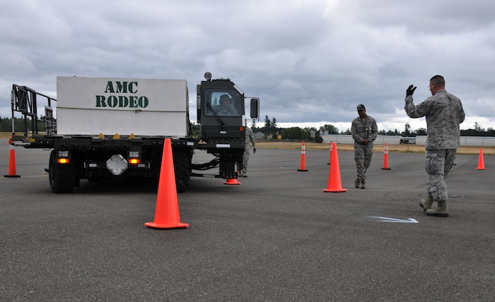 A driver looks to his spotter, July 26, 2011, at Joint Base Lewis-McChord, Wash., during a 25K loader driving course. The event was part of Air Mobility Rodeo 2011, a biennial international competition that focuses on mission readiness, featuring airdrops, aerial refueling and other events that showcase the skills of mobility crews from around the world. (U.S. Air Force photo/Airman 1st Class Jared Trimarchi) 

