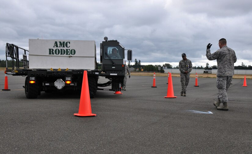A driver looks to his spotter, July 26, 2011, at Joint Base Lewis-McChord, Wash., during a 25K loader driving course. The event was part of Air Mobility Rodeo 2011, a biennial international competition that focuses on mission readiness, featuring airdrops, aerial refueling and other events that showcase the skills of mobility crews from around the world. (U.S. Air Force photo/Airman 1st Class Jared Trimarchi) 

