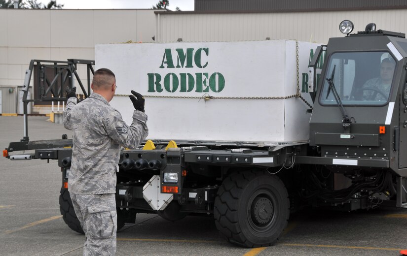 An Airman signals the driver of a Halvorsen loader, July 26, 2011, at Joint Base Lewis-McChord, Wash., during a 25K loader driving course. The event was part of Air Mobility Rodeo 2011, a biennial international competition that focuses on mission readiness, featuring airdrops, aerial refueling and other events that showcase the skills of mobility crews from around the world. (U.S. Air Force photo/Airman 1st Class Jared Trimarchi) 
