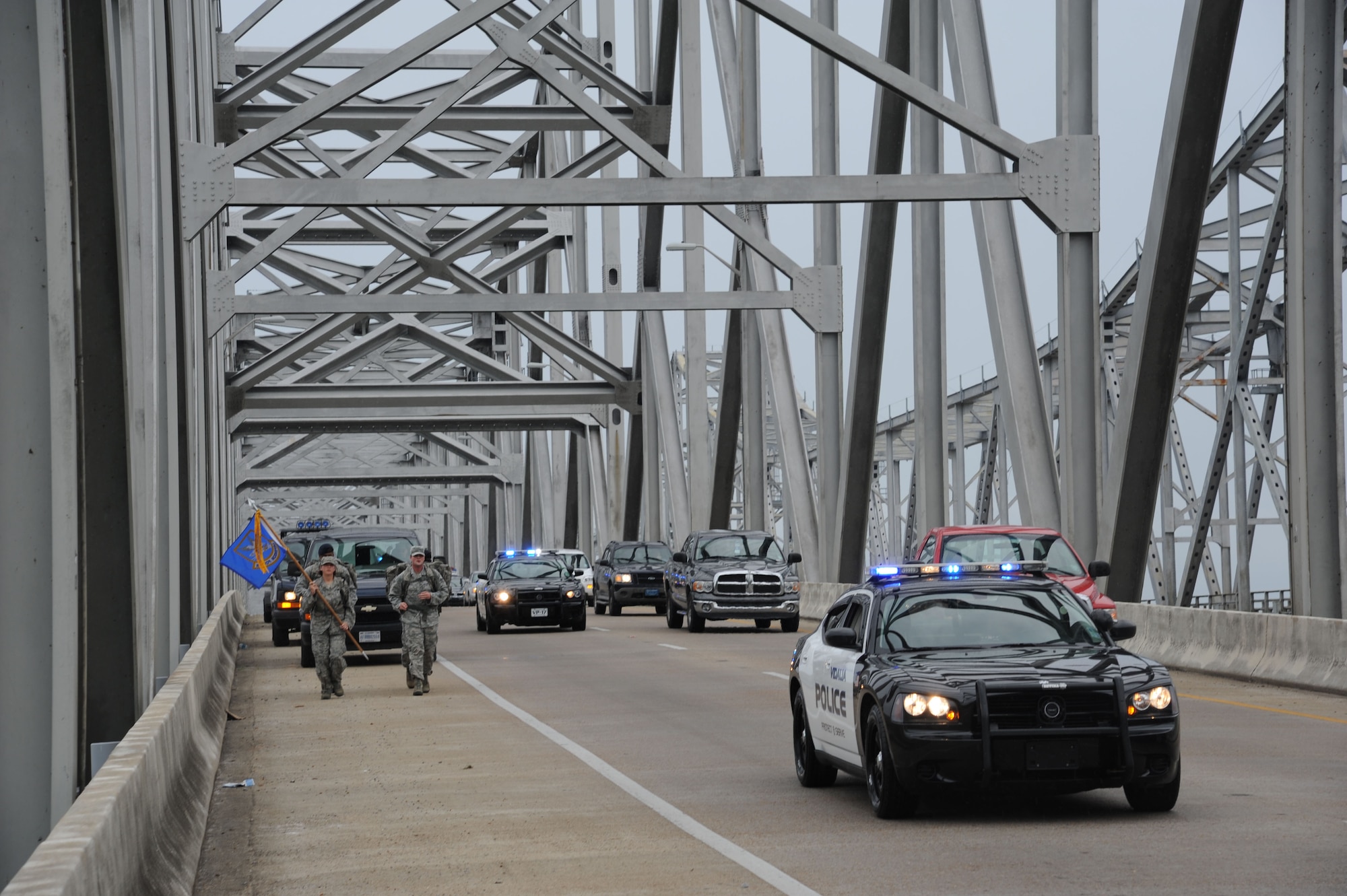 Members of the 14th Security Forces Squadron from Columbus Air Force, Miss., volunteering for the “Ruck March to Remember,” double-time over the Vidalia-Natchez Bridge across the Mississippi River July 26. The security forces members were escorted across the bridge by the Vidalia Police Department. (U.S. Air Force photo/Airman 1st Class Chase Hedrick)