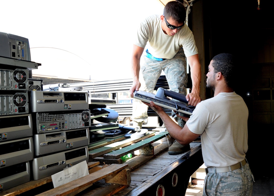 Staff Sgt. Jeremiah Greene, 89th Aerial Port Squadron air transportation specialist, hands computer equipment to Airman 1st Class John Mark, 744th Communications Squadron base equipment custodian, during a mass automated data processing equipment turn-in July 27.  The ADPE turn-in allowed the 89th Airlift Wing to turn over all unused computer equipment to the 744 CS in preparation for the 89 AW upcoming compliance inspection.(U.S. Air Force photo by Airman 1st Class Bahja J. Jones) 