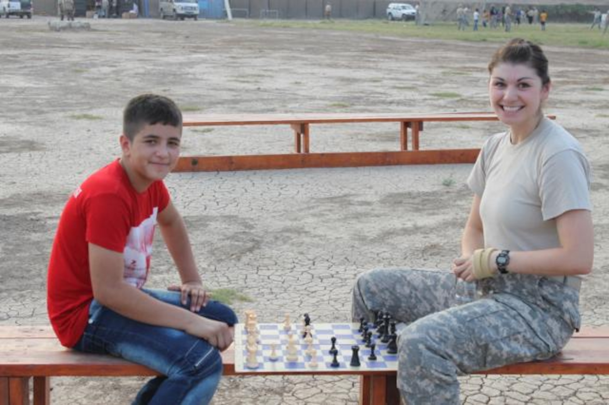Army Captain Megan Gilbert plays chess with one of the Iraqi Boy Scouts. (Photo provided)