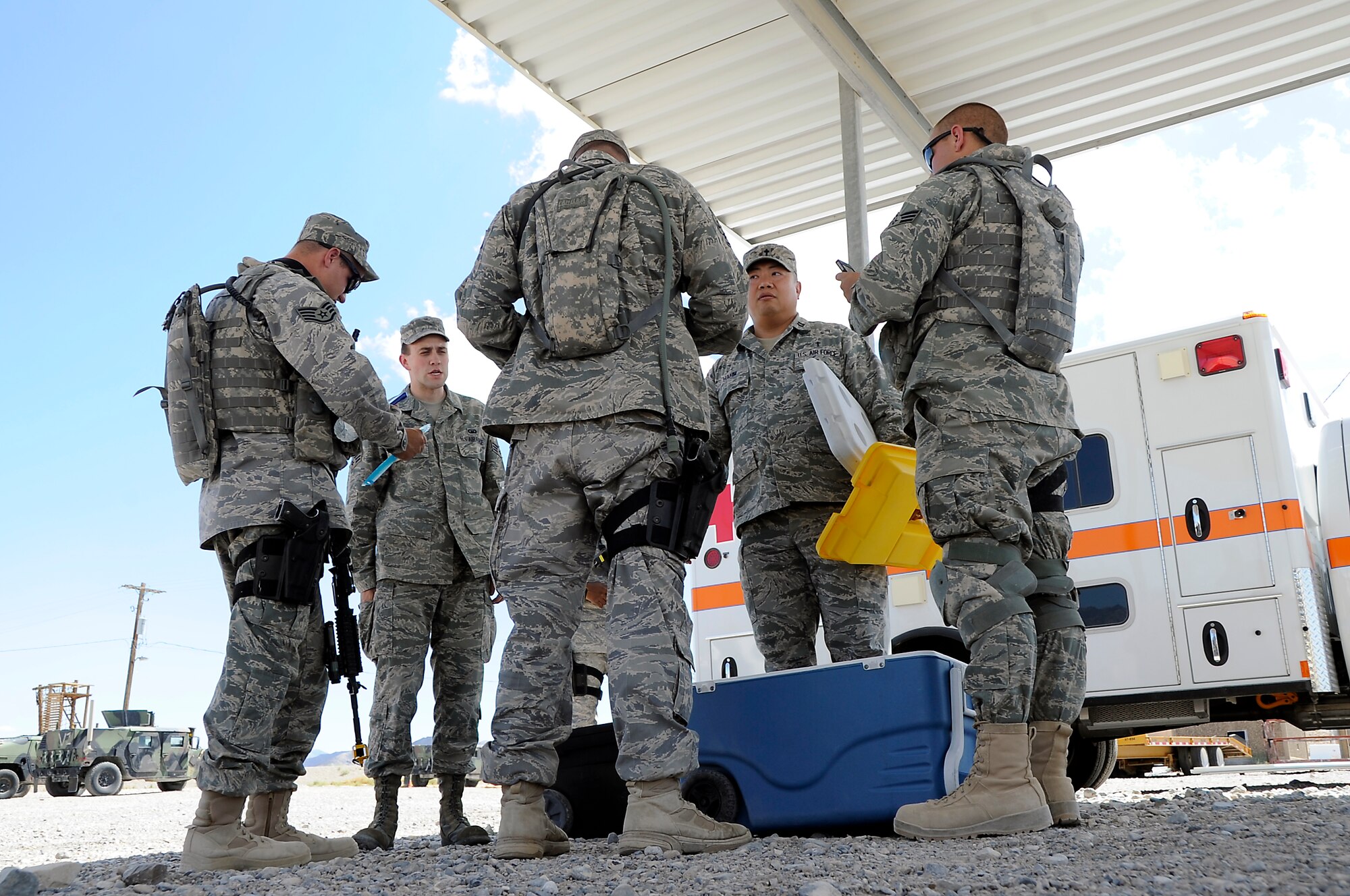 CREECH AIR FORCE BASE, Nev. -- A U.S. Air Force chaplain and his chaplain assistant, both members of the 432d Wing/432d Air Expeditionary Wing, pass out water and snacks July 19 to Security Forces Airmen during a visit to the 99th Ground Combat Training Squadron training range in the Nevada desert. The two chaplains routinely visit Airmen on the range to increase morale during SF training. (Photo by 432d Wing/432d Air Expeditionary Wing Public Affairs/Released)
