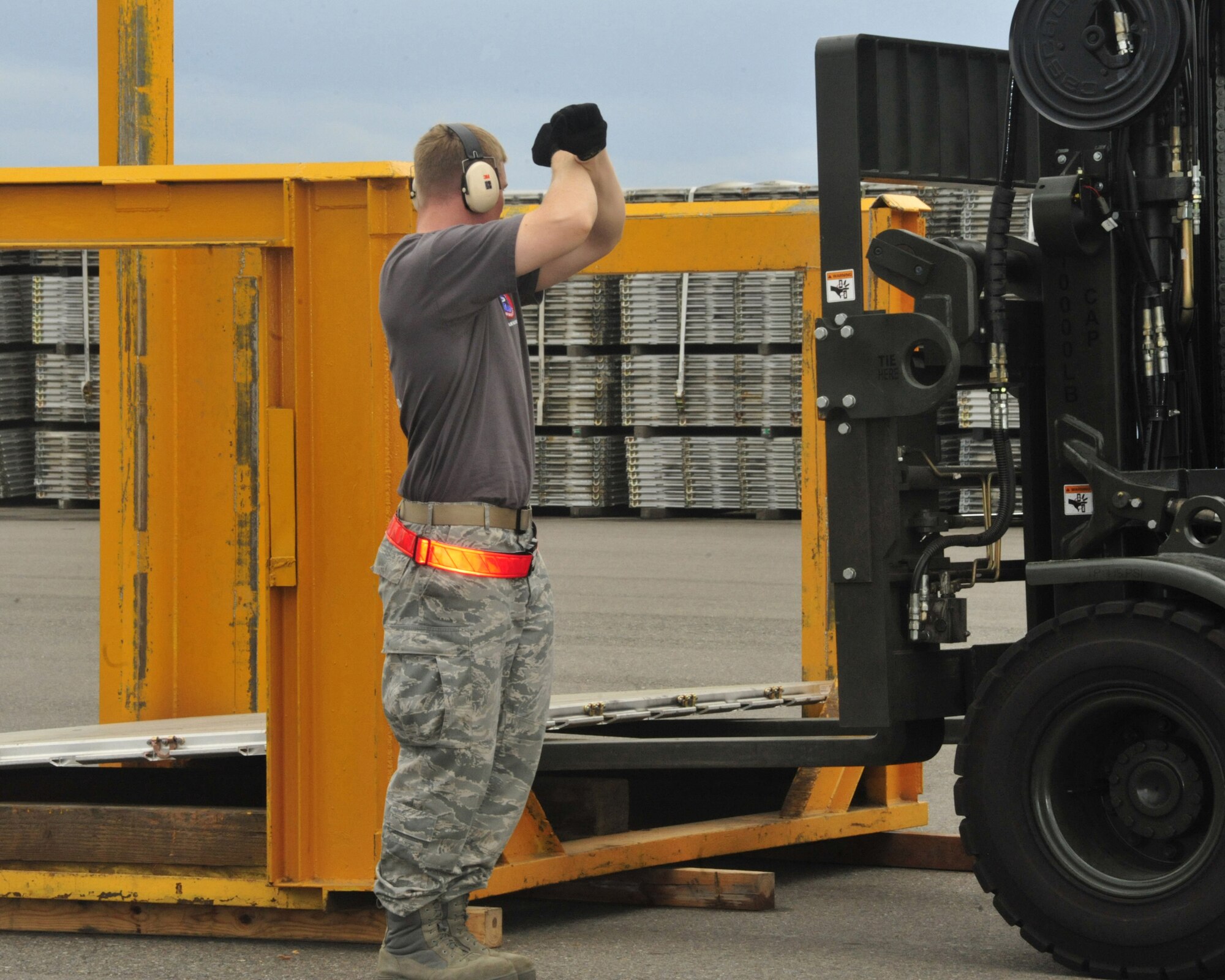 Staff Sgt. Chris Lenane, 62nd Aerial Port Squadron Rodeo team member, directs another team member, to forklift a pallet onto a pallet stacker during the 10K forklift obstacle course competition July 25, 2011, at Joint Base Lewis-McChord, Wash. Stacking a pallet was the other scored portion of the obstacle course as part of Air Mobility Rodeo 2011. (U.S. Air Force Photo/Staff Sgt. Frances Kriss) 