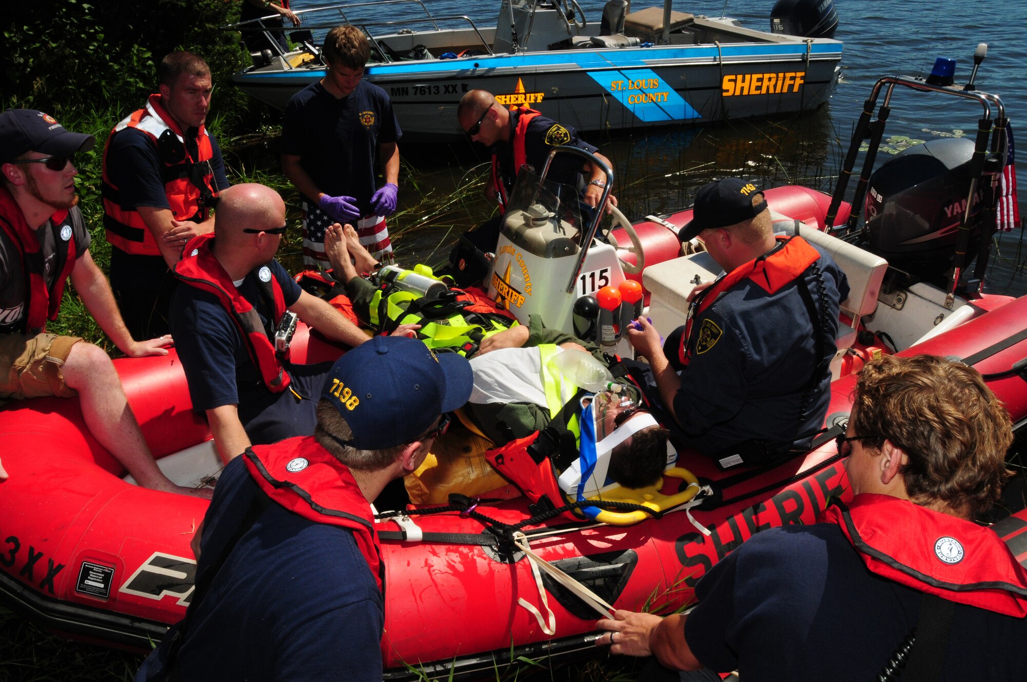 Members of the St. Louis County Rescue Squad prepare Capt. David A. Betts for transport during a major accident response exercise at Fish Lake, Duluth, Minn. July26, 2011.  The exercise simulated rescuing a pilor after an F-16 crashed into a lake.  (U.S. Air Force photo by Tech. Sgt. Scott G. Herrington)