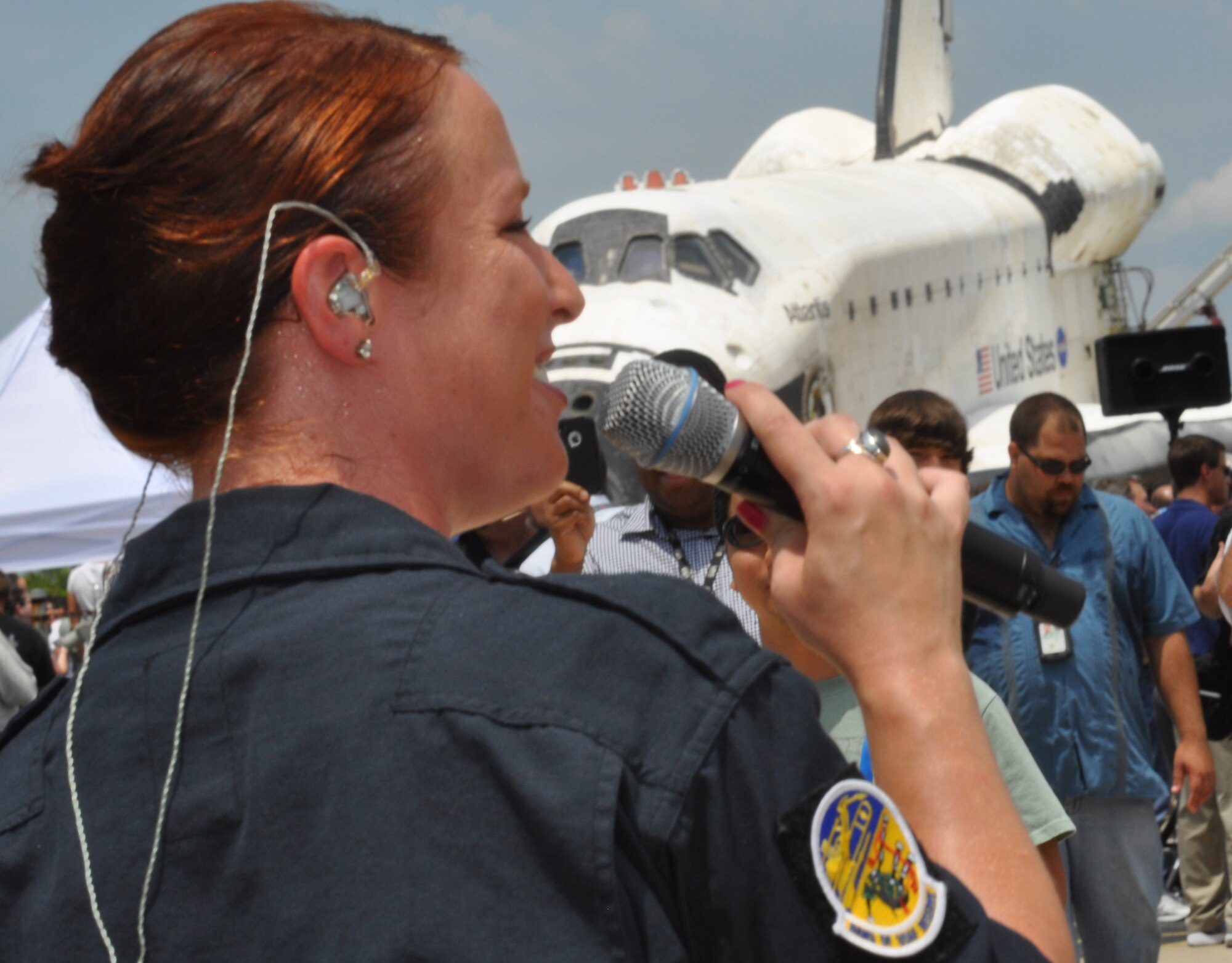 Airman 1st Class Jill Diem, a vocalist with the Band of the U.S. Air Force
Reserve's High Flight, sings before 3,300 spectators at the Kennedy Space
Center in Florida, July 21. The event celebrated the final landing of
Shuttle Atlantis and 30 years of NASA's space shuttle program. Atlantis
conducted its' final landing at 5:57 a.m. NASA officials wheeled the shuttle
down the runway for the event. (U.S. Air Force photo/Candice Allen)
