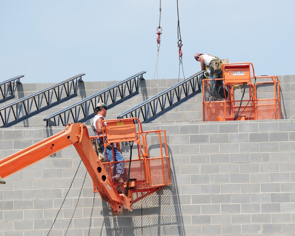Workers putting into place steel beams for the roof of the indoor firing range.  The 21,000 square foot building will allow military members to train on base and become proficient in small arms qualifications in all types of weather.  This 6.3 million dollar project is expected to be ready for March 2012. (U.S. Air Force photo by Peter Borys)
