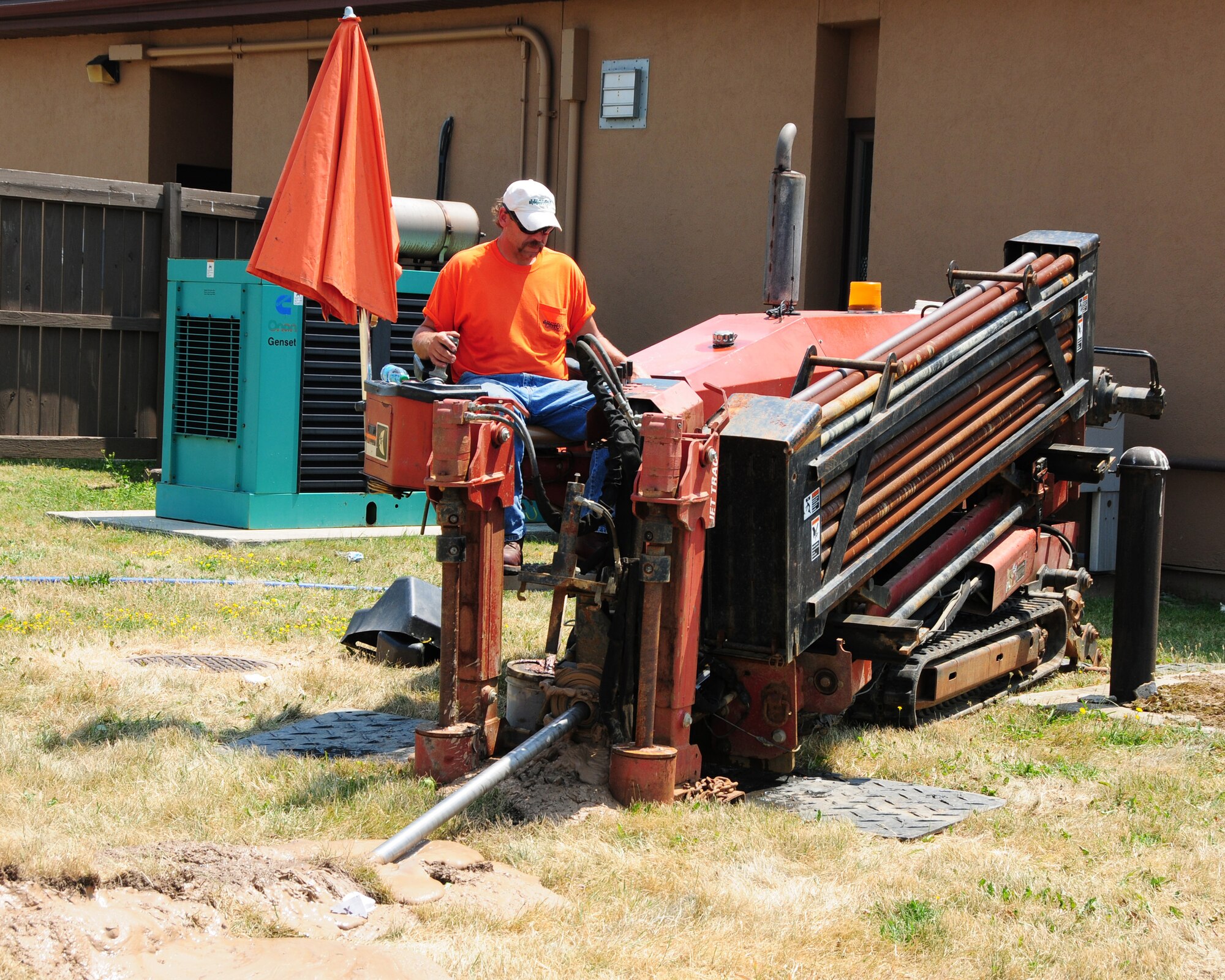 A construction worker operates a horizontal drilling rig at the Niagara Falls Air Reserve Station. The procedure known as "reaming" enables the contractor to lay piping in the ground for communication cables without digging a trench. (U.S. Air Force Photo by Peter Borys)