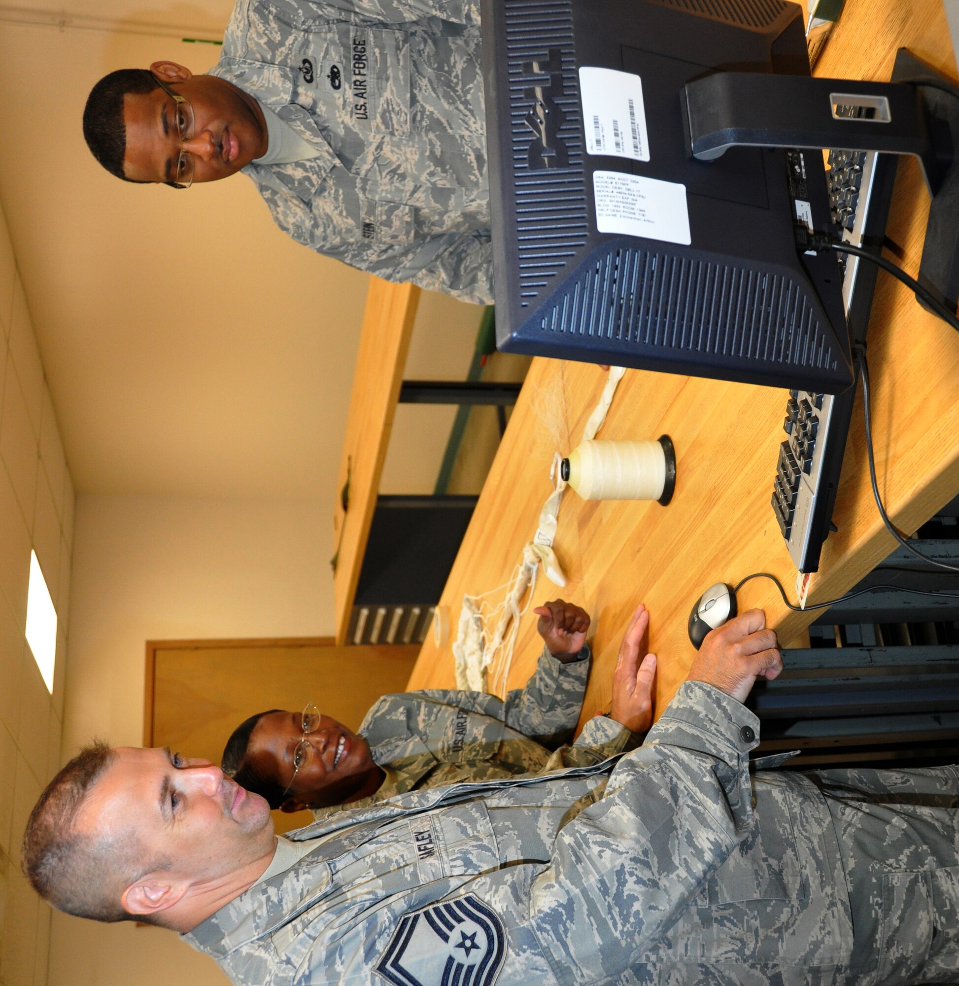 Senior Master Sgt. Rob Safley, left, studies the tech. order for a drogue parachute system, designed to stabilize an ejection seat once it's rocketed out of an aircraft.  Staff Sgt. Kim McBride, aircrew flight equipment technician, and Tech. Sgt. Timothy Stein, NCOIC of the Oxygen Section, were using the tech. orders to inspect and pack the chute.  Safley supervises 12 Air Force reservists in the 301st Operations Support Flight's AFE section and was named the 2010 Outstanding Air Reserve Component Aircrew Flight Equipment Senior Noncommissioned Officer of the Year for the Air Force.