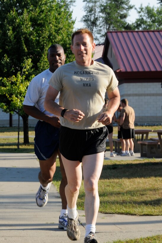 Master Sgt Michael McGann of the 107th Weather Flight and Master Sgt. Ethan Boyd, the unit's first sergeant, begin the run portion of their morning physical training routine while attending the annual Gray Wolverine training exercise held at Combat Readiness Training Center Alpena, Mich., July 27, 2011. McGann and Boyd are both members of the Michigan Air National Guard, assigned to Selfridge Air National Guard Base. (U.S. Air Force photo by TSgt David Kujawa)