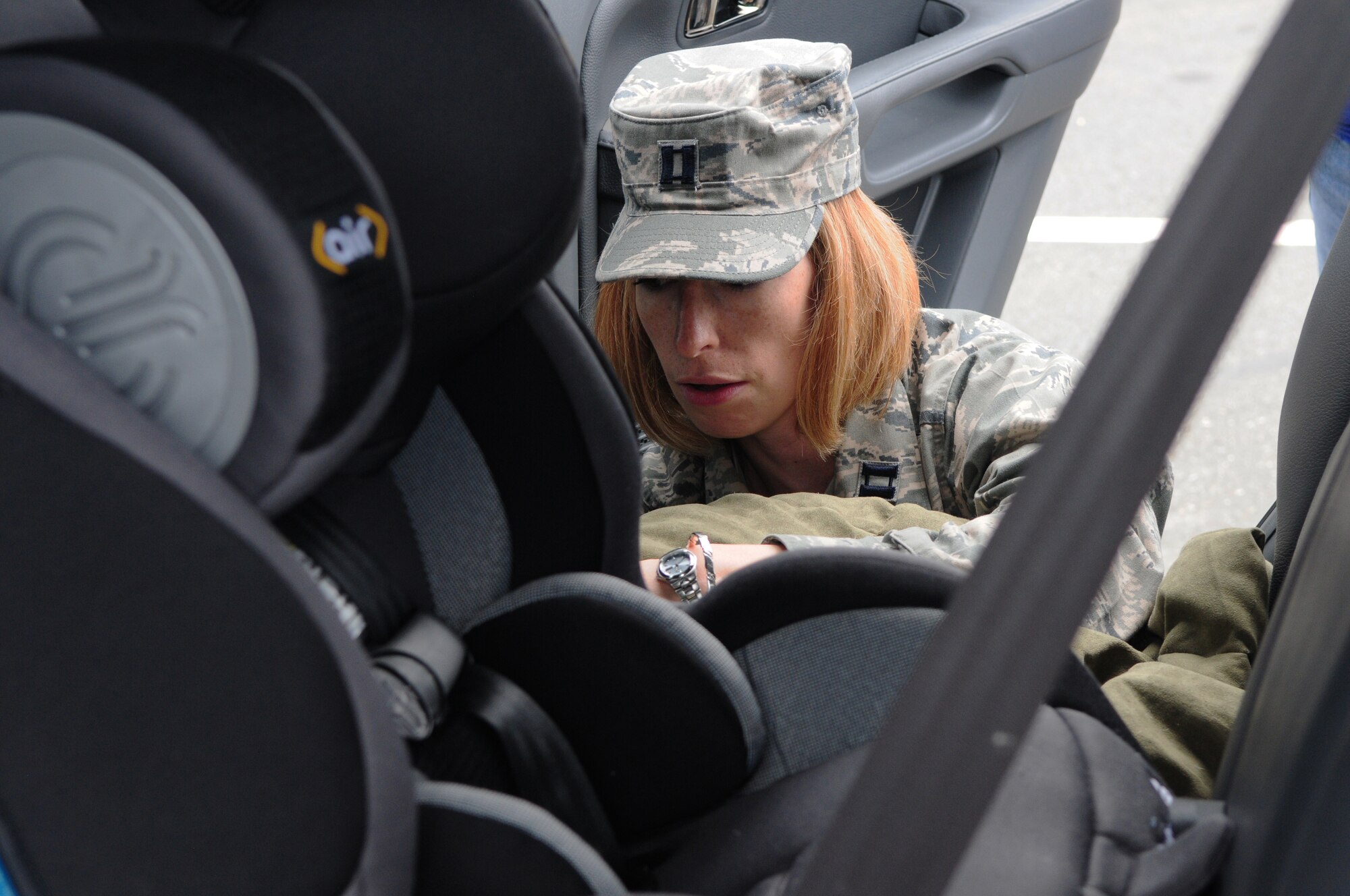 SPANGDAHLEM AIR BASE, Germany – Capt. Gretchen Haywood, 52nd Medical Operations Squadron Education and Developmental Intervention Services audiologist, works to ensure a child’s car seat is properly secured here July 22. The 52nd MDOS EDIS Clinic hosted an event to raise awareness about recent changes in government laws and the transition periods between forward- and backward-facing child seats.  (U.S. Air Force photo/Airman 1st Class Matthew B. Fredericks)
