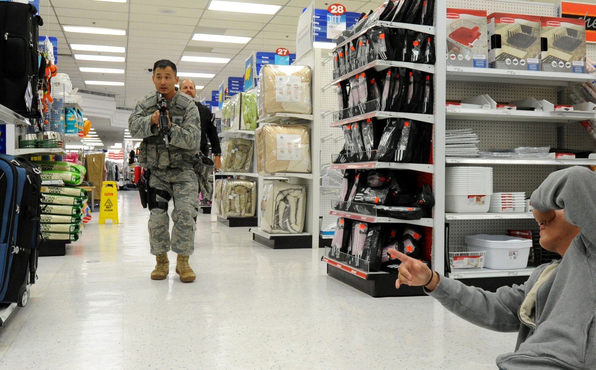 MISAWA AIR BASE, Japan -- Tech. Sgt. Ryan Taira, left, 35th Security Forces Squadron, moves in to actively engage a simulated shooter during a High Risk Response training course held at the Base Exchange 22 July.  The HRRT course was conducted by the Pacific Air Force's Mobile Team and is part of a high-risk response program taught to base security members which allows them to respond to an active shooter incident. (U.S. Air Force photo/Staff Sgt. April Quintanilla)