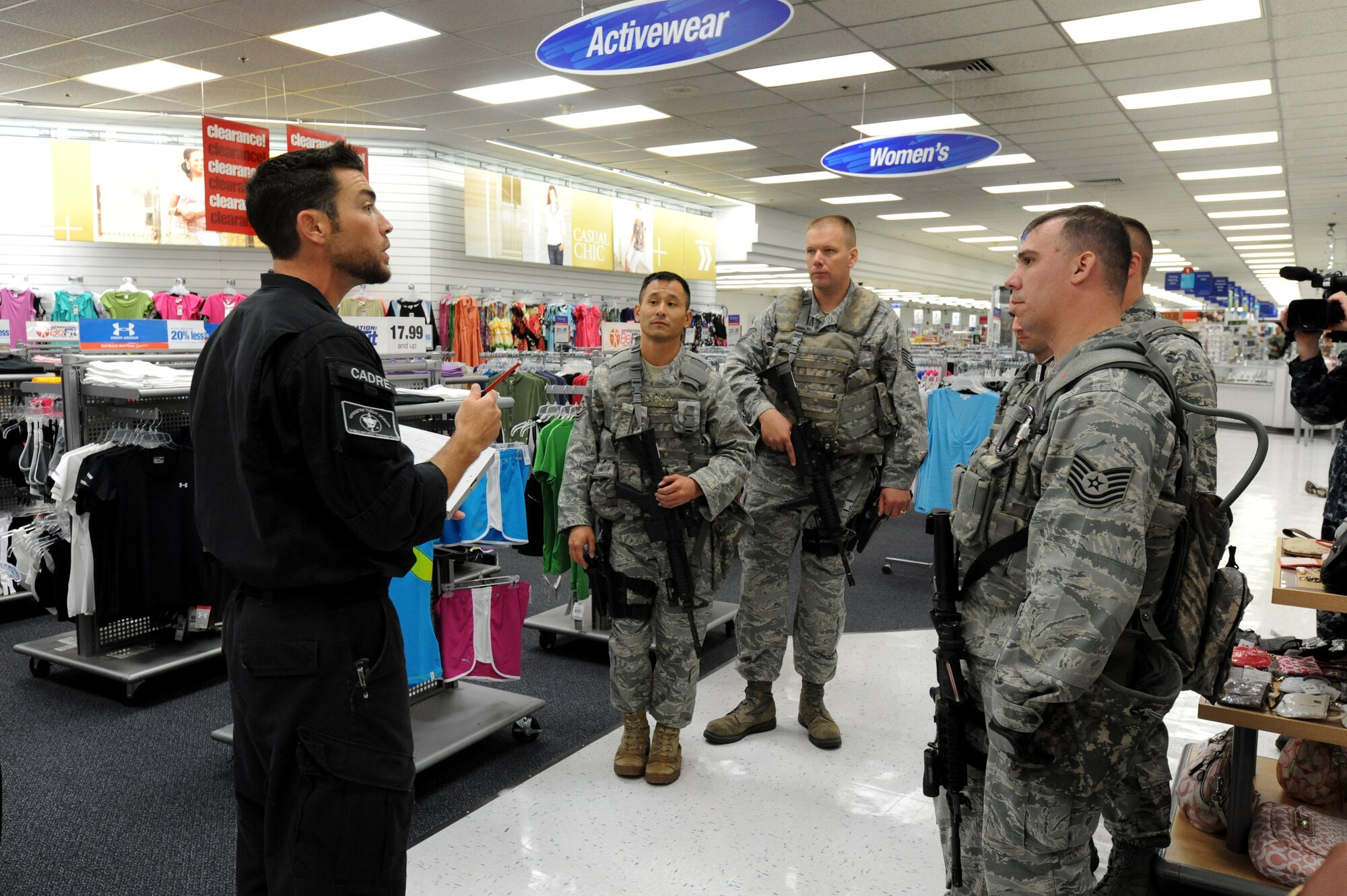 MISAWA AIR BASE, Japan -- Tyler Hare, left, a High Risk Response Training course instructor, talks with 35th Security Forces members during the HRRT course held at the Base Exchange 22 July.  The HRRT course was conducted by the Pacific Air Force's Mobile Team and takes the members through newly developed tactics and techniques grounded in contemporary Special Weapons and Tactics (SWAT) training tailored to eliminate various threat encounters. (U.S. Air Force photo/Staff Sgt. April Quintanilla)