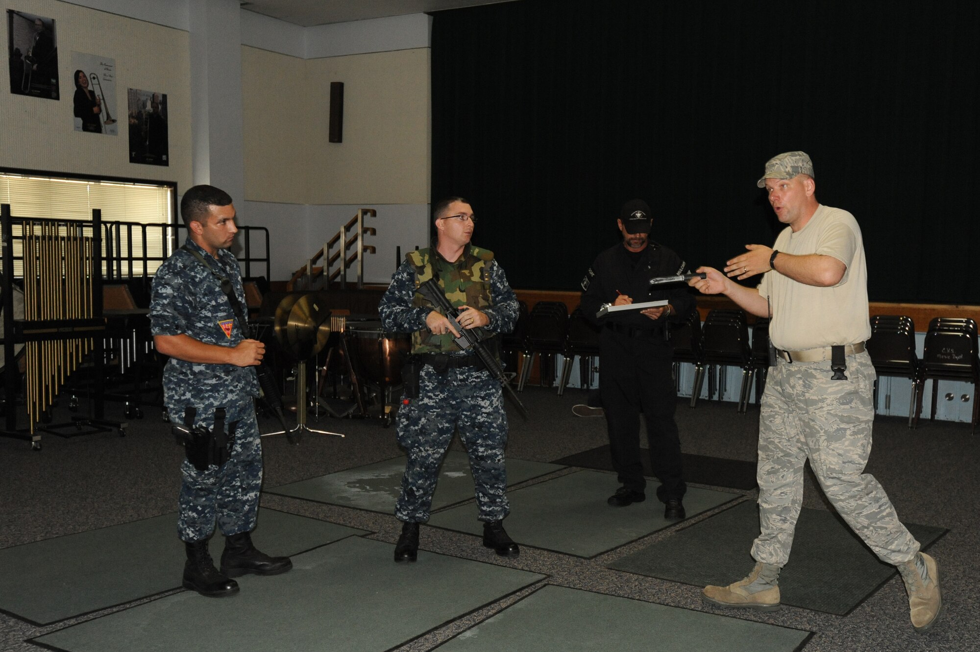 MISAWA AIR BASE, Japan -- Master-at-Arms Seaman Benjamin Jafari, left, and Gunner's Mate First Class Patrick Ryan, center, members of the Naval Air Facility Security Department, take direction from Tech. Sgt. Eric Parks, right, during a High Risk Response training course held at Edgren High School 22 July.  The HRRT course was conducted by the Pacific Air Force's Mobile Team and is part of a high-risk response program taught to base security members which allows them to respond to an active shooter incident. (U.S. Air Force photo/Staff Sgt. April Quintanilla)