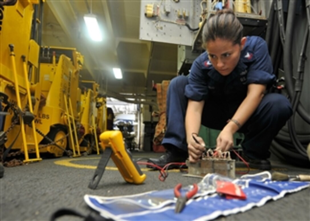 Petty Officer 2nd Class Maria Arreedondo uses a flow divider while fixing a forklift battery charging station in the hangar bay of the aircraft carrier USS Ronald Reagan (CVN 76) in the Gulf of Aden on July 23, 2011.  The Ronald Reagan is conducting operations supporting maritime security operations and theater security cooperation efforts in the U.S. 5th Fleet area of responsibility.  