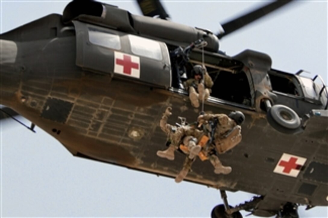 U.S. Army Staff Sgt. Travis Brown and a German soldier are hoisted up into a UH-60L Black Hawk helicopter during rescue hoist training at Camp Marmal, Afghanistan, on July 16, 2011.  Brown is a flight medic assigned to 1st Cavalry Division's Company C, Task Force Lobos, 1st Air Cavalry Brigade.  The German soldiers are part of an extrication team that is training at Camp Marmal to familiarize themselves with usage of the aircraft hoist.  