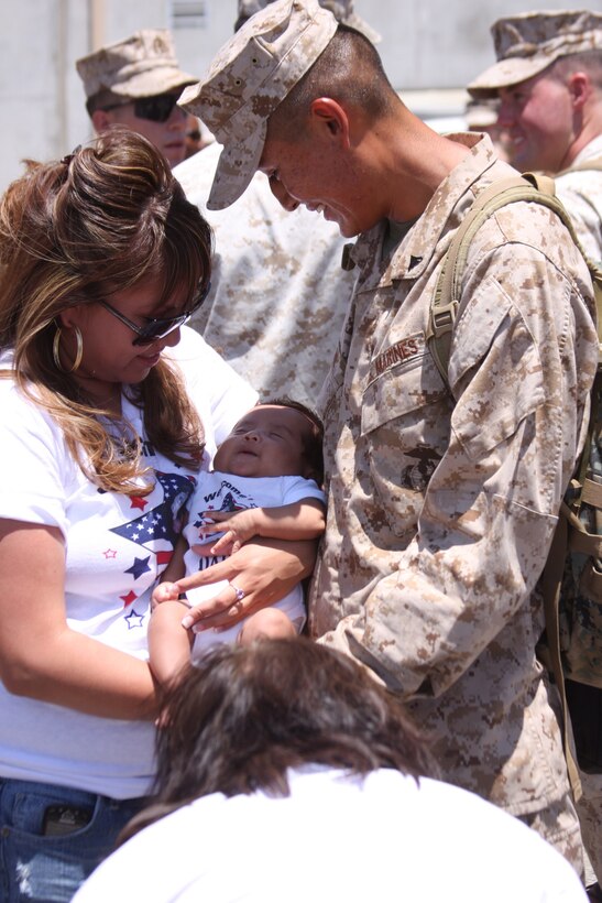 Lance Cpl. Edwardo Santillan meets his niece, Jaylin, for the first time shortly after stepping off the bus during the homecoming for Company D, 1st Tank Battalion, July 28, 2011.