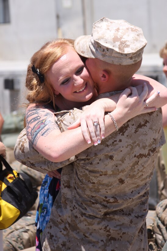 Courtney Marsh leaps into her husband’s arms shortly after he exited the bus during the 1st Tank Battalion, Company D homecoming at the 1st Tanks compound July 28, 2011.