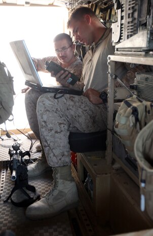 Lance Cpl. Charles Shoenfelt (foreground) and Cpl. Andrew Black (background), both ground radio intermediate repairers with 2nd Marine Logistics Group (Forward), install upgrades on a radio at Forward Operating Base Marjah, Afghanistan, July 28, 2011. Shoenfelt and Black are part of a three-man communication team that travels around Helmand province maintaining radios and other communication devices for explosive ordnance disposal teams.