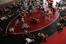 Members of the All-Marine Wrestling Team lead high school athletes in yoga exercises before conducting a Greco-Roman training session at the All-Marine Wrestling Camp July 28. More than 120 wrestlers received one-on-one instruction in Freestyle and Greco-Roman techniques. Recruiting Station Twin Cities hosted the six-day camp to promote athletic and academic excellence. For additional imagery from the event, visit www.facebook.com/rstwincities.