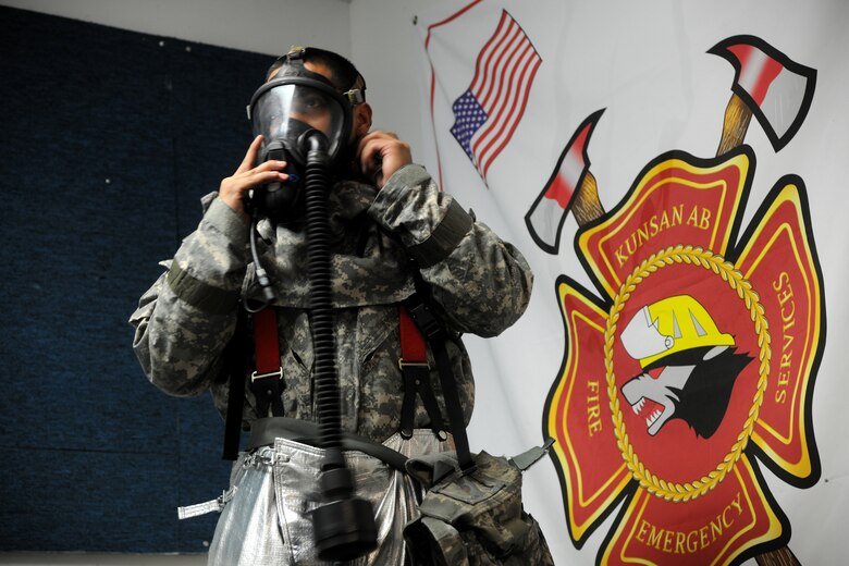 KUNSAN AIR BASE, Republic of Korea -- Staff Sgt. Timothy Cruz, 8th Civil Engineer Squadron firefighter, practices donning and doffing procedures with their new Joint Firefighter's Integrated Response Ensemble (J-FIRE) suits here July 28. Airmen were participating in a final field evaluation of the suit testing the time to put on the J-FIRE suits versus the previous version. (U.S. Air Force photo/Staff Sgt. Rasheen Douglas)