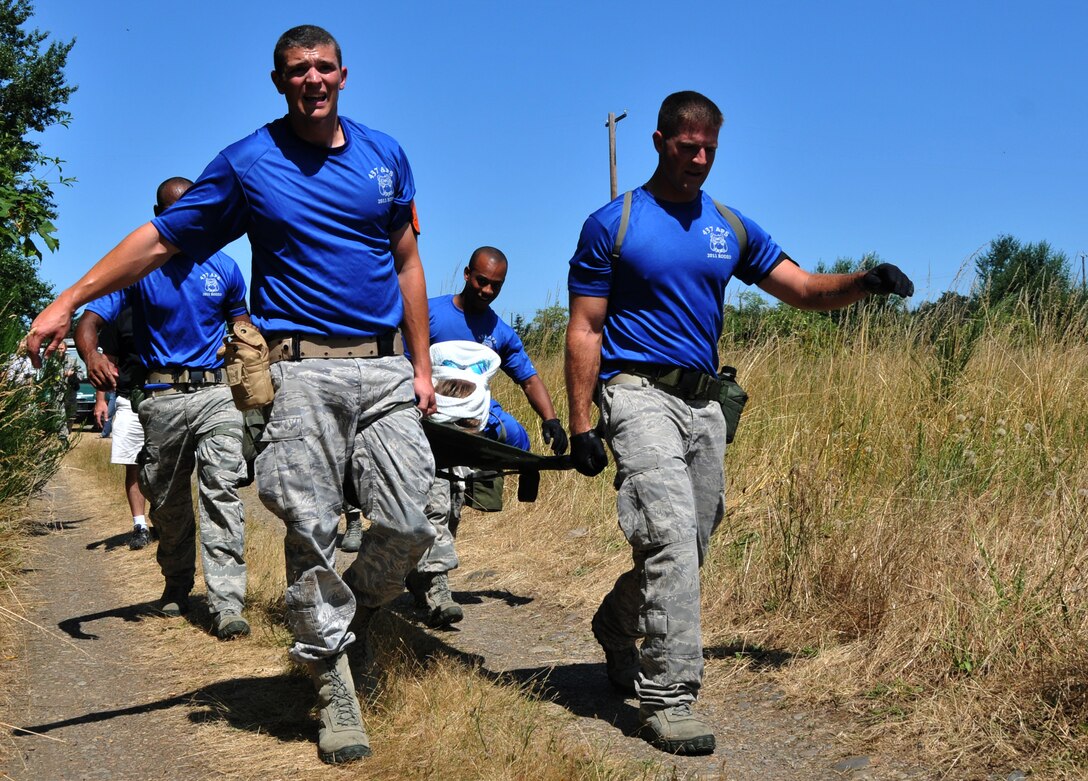 Airmen carry a wounded troop on a litter, July 28, 2011 at Joint Base Lewis-McChord, Wash., during an aerial port obstacle course. The event was part of Air Mobility Rodeo 2011, a biennial international competition that focuses on mission readiness, featuring airdrops, aerial refueling and other events that showcase the skills of mobility crews from around the world. (U.S. Air Force photo/Airman 1st Class Jared Trimarchi)  